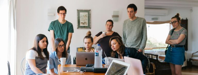 Group of young professionals engaged in a collaborative meeting in a modern office setting.